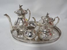 An ornate EPBM hand chased four piece tea and coffee service with bird finial on an oval gallery