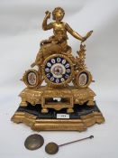 A gilt metal porcelain faced figural garniture clock