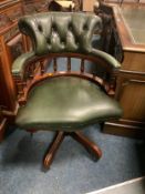 A modern green leather swivel office armchair