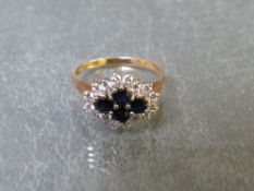 AN 18CT GOLD LADIES CLUSTER DRESS RING, set with four central sapphires in a cross formation,