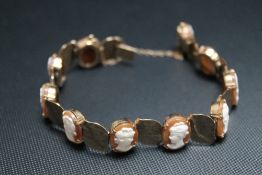 A HALLMARKED 9 CARAT GOLD CAMEO PANEL BRACELET, having alternating oval claw set cameos, approx