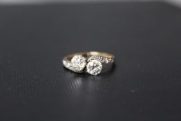 A TWO STONE DIAMOND CROSSOVER RING, set with two brilliant cut diamonds of an estimated half a carat