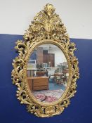 A LARGE CONTEMPORARY LOUIS XVI STYLE GILT WOOD ORNATE WALL MIRROR, of oval form, approximate H