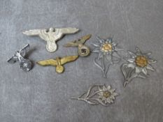THIRD REICH WEHRMACHT - THREE EDELWEISS ALPINE CORPS CAP BADGES, together with three eagle and