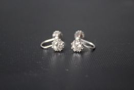 A PAIR OF DIAMOND SOLITAIRE EARRINGS, the diamonds being in an illusion setting and set in 9ct white