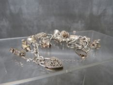 A HALLMARKED SILVER CHARM BRACELET AND CHARMS, overall weight approx 62.6 g