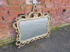 A CONTINENTAL CARVED SHAPED PIERCED WALL MIRROR, bearing label verso and stamp 'Ateliers Armand