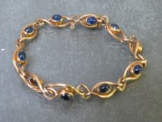 AN EDWARDIAN CABOCHON SAPPHIRE SET YELLOW METAL FANCY LINK BRACELET, set with ten sapphires,