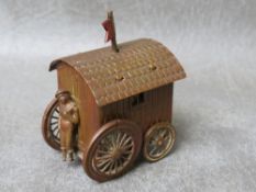 AN UNUSUAL VINTAGE TAPE MEASURE IN THE FORM OF A BATHING BELLE ON THE STEPS OF A CARAVAN, the figure