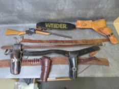 FOUR LEATHER WESTERN BELTS WITH GUN HOLSTERS, together with another leather belt with metal eagle