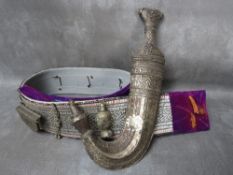 AN OMANI JAMBIYA DAGGER, in white metal scabbard, with decorative belt, blade L 17 cm, overall L