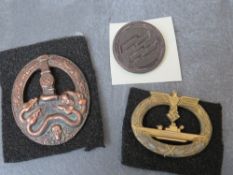A THIRD REICH U BOAT GILT BADGE, together with an Anti-partisan badge and an SS badge