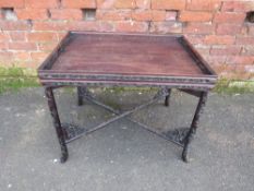 A LATE 19TH CENTURY CARVED EASTERN RECTANGULAR TABLE ON FOLDING STAND, the top with pierced gallery,