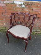 AN EARLY 20TH CENTURY MAHOGANY BEDROOM CHAIR, with unusual open fretwork detail, raised on shaped