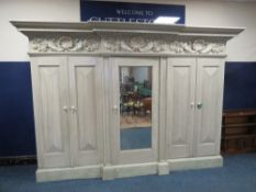 A LARGE AND IMPRESSIVE BREAKFRONT PAINTED FIVE DOOR WARDROBE, the central mirrored door opening to