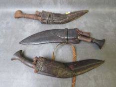 THREE EARLY 20TH CENTURY NEPALESE KUKRI KNIVES WITH SHEATHS