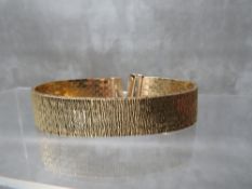 A VINTAGE 9CT GOLD FLEXIBLE PANEL BRACELET, with bark effect finish, L 18.5 cm, approximate weight