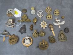 A COLLECTION OF TWENTY FIVE MILITARY CAP BADGES AND BUTTONS