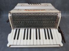 A CASED MERIDIAN PIANO ACCORDION