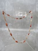 A 9CT GOLD AND GEMSET FANCY LINK NECKLACE, the reticulated links interspersed with amber and clear
