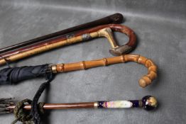 A PORCELAIN HANDLED VINTAGE PARASOL, together with another parasol and three walking sticks, average