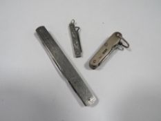 An antique silver pocket knife together with a white metal folding button hook and an advertising