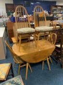 An Ercol light dropleaf table and four hoop back chairs