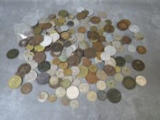 A tin of assorted world coins, to include tokens and medallions etc.