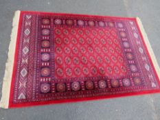 A modern Iranian silk style rug with fringe in red, blue and cream colourway, approx 187 x 117 cm