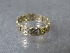 A yellow metal Celtic style ring, indistinct marks, ring size S, approximate weight 3.24