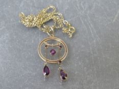 An unmarked yellow metal amethyst set Edwardian pendant, suspended on a 9ct gold chain,