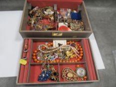 A box of vintage jewellery including brooches and rings
