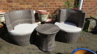 Two grey woven rattan barrel garden seats with table and cushions