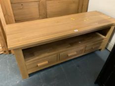 A modern low media unit with three drawers