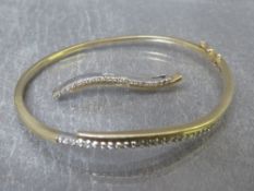 A 9ct yellow and white gold diamond set pendant, together with a matching hinged bangle having