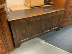 An antique oak four panel carved coffer W 155 cm