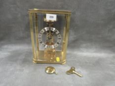 A Hermle West German cased skeleton clock with key and pendulum