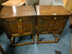 A pair of oak linen fold small cabinets