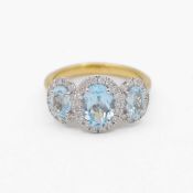 A 9k white and yellow gold blue topaz and diamond set triple cluster ring.