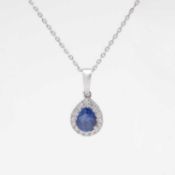 An 18k white gold pear-cut sapphire and diamond cluster pendant on 18k chain.
