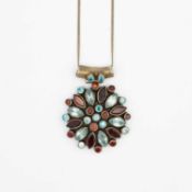 A silver garnet and blue stone pendant, on a silver neck chain.