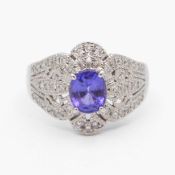A stylish platinum dress ring set with an oval tanzanite and diamonds.