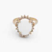 A 14k oval white opal and diamond cluster ring.