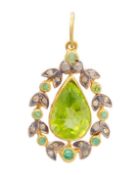 A silver gilt, peridot, diamond, and emerald pendant.