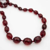 A faceted cherry amber-style graduated bead necklace.