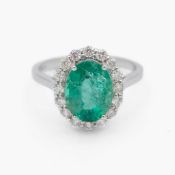 An attractive 18k white gold emerald and diamond cluster ring.