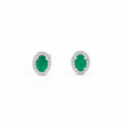 A pair of 18k white gold oval emerald and diamond cluster stud earrings.