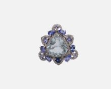 A silver dress ring set with a large trilliant cut aquamarine, tanzanites, kyanites and diamonds.