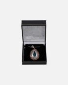 A silver pendant set with a large pear cut aquamarine, square pink tourmalines and diamonds.