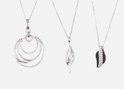 Three silver pendant necklaces.